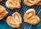 Homemade sugar buns on a cooling rack with sugar for sprinkling. Palmiers, elephant ear, puff pastry cookie