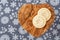 Homemade sugar cookies on a wood heart shaped cutting board, snowflake background
