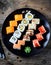 Homemade sushi with salmon, tobiko caviar, omelet, cucumber, sesame and soft cheese on old wooden background. Rustic style.