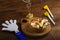 Homemade sweet gometashi cookies for Purim laid out on a wooden board in a bread basket next to rattles and a whistle.