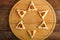 Homemade sweet gometashi triangle cookies for Purim laid out on a board in the form of Magen David.