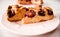 Homemade sweet round plum cake New York Times cutted on plate with cups, glasses of tea, coffee at back on holyday Breakfast or bi