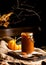 Homemade sweet and tasty pumpkin caramel n glass jar stands on wooden board