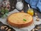 Homemade Swiss Closed Walnut Pie with Almonds and Walnuts. Located on a dark wooden table, next to a jug of milk, orange jam and