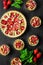 Homemade tarts with strawberry and rhubarb on black wooden background. Top view. Rustic style