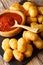 Homemade tater tots with tomato sauce close up. Vertical
