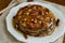 Homemade thin pancakes with honey and pecan nuts on white porcelain plate