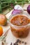 Homemade tomato sauce in glass jar with fresh tomatos, garlic, onion, herbs and spices, close up