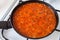 Homemade Tomato Sauce with vegetables simmering in frying pan on stove