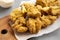 Homemade traditional japanese fried chicken Karaage on a rustic wooden board over gray background, low angle view. Closeup