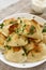 Homemade traditional polish fried potato pierogies on a white plate, low angle view. Closeup