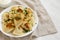 Homemade traditional polish fried potato pierogies on a white plate, low angle view. Space for text