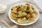 Homemade traditional polish fried potato pierogies on a white plate, side view. Close-up