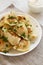 Homemade traditional polish fried potato pierogies on a white plate, side view. Close-up