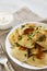 Homemade traditional polish fried potato pierogies on a white plate, side view. Closeup