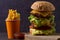 Homemade triple decker burger and fries on dark wooden background.