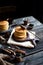 Homemade two stacks of pancakes on wooden boards with pouring honey and honey stick