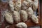 Homemade ugly dumplings lie on a board sprinkled with flour