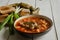 Homemade ukrainian borsch - beetroot soup in a bowl. Green onion, bread, bacon with herbs and pickles