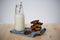 Homemade vegan oat cookie with banana, date and almond topped with chocolate placed next to a glass with milk