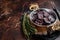 Homemade venison cured sausage.with herbs in a skillet. Dark background. Top view. Copy space