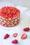 Homemade Victoria summer dessert layer cake with whipped cream topping, decorated with strawberries. Close up on the