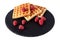 Homemade waffles with berries on black stone plate isolated. Belgian waffle with fruit raspberry on white background.