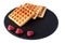 Homemade waffles with berries on black stone plate isolated. Belgian waffle with fruit raspberry on white background.