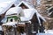 Homemade wooden bird`s feeder in winter, under snow