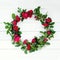The homemade wreath of roses on white wooden table flat lay. With copy space