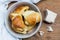 Homemade yeast croissants in a ceramic bowl and raw yeast on a wooden background