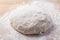 Homemade yeast dough freshly prepared for pizza or bread on wooden background.