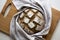 Homemade yeast sourdough rye wholegrain bread with Diamond Crosshatch scoring pattern on a wooden board with kitchen towel.