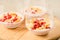 Homemade yogurt with garnet grains and flakes in glass/Homemade yogurt with garnet grains and flakes in glass on a wooden tray.