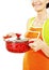 Homemaker in an apron holding pan with ready meal, soup