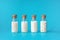 Homeopathic globules in four glass bottles on blue background. Alternative homeopathy medicine herbs, healthcare and