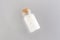 Homeopathic globules in a glass bottle on gray background