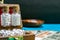 Homeopathic medicine glass bottles of pills in wooden box on Indian currency and blue surface with blurred wood spoon and dark