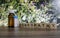 A homeopathy concept - Homeopathic medicine bottles on wooden surface with wild flower background and slant homeopathy text on