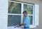 Homeowner caulking window weatherproofing home against rain water and storms