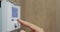 The homeowner regulates the temperature in the house on the electronic control panel