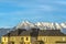 Homes with horizontal wall didings against snow peaked mountain and blue sky