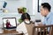 Homeschool Asian little young girl learning online class from school teacher by digital remote internet meeting due to coronavirus