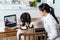 Homeschool Asian little young girl learning online class from school teacher by digital remote internet meeting due to coronavirus