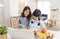 Homeschool Asian little young girl student learning sitting on table working with his mother at home