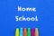 Homeschool. Words or typed text on blue board. Multi-colored crayons. Top view