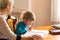 Homeschooling grandmother teaching smart boy, child at home