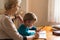 Homeschooling grandmother teaching smart boy, child at home