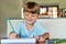 Homework time is happy time. a little boy sitting at a desk and writing on a notepad at home.