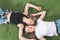 Homosexual couple in casual clothes relaxing on the grass